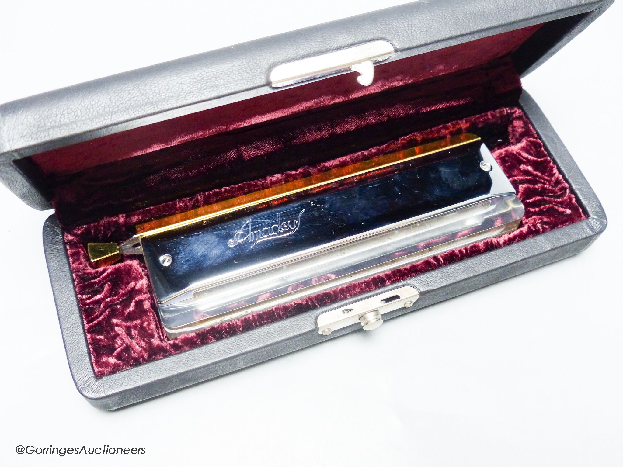 An M.Hohner Amadeus cased harmonica